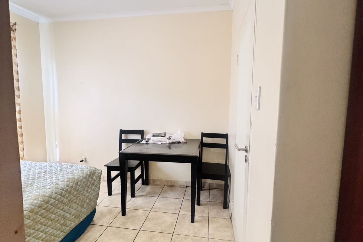 A bedroom featuring tiled flooring and a neutral color palette, viewed from the doorway.