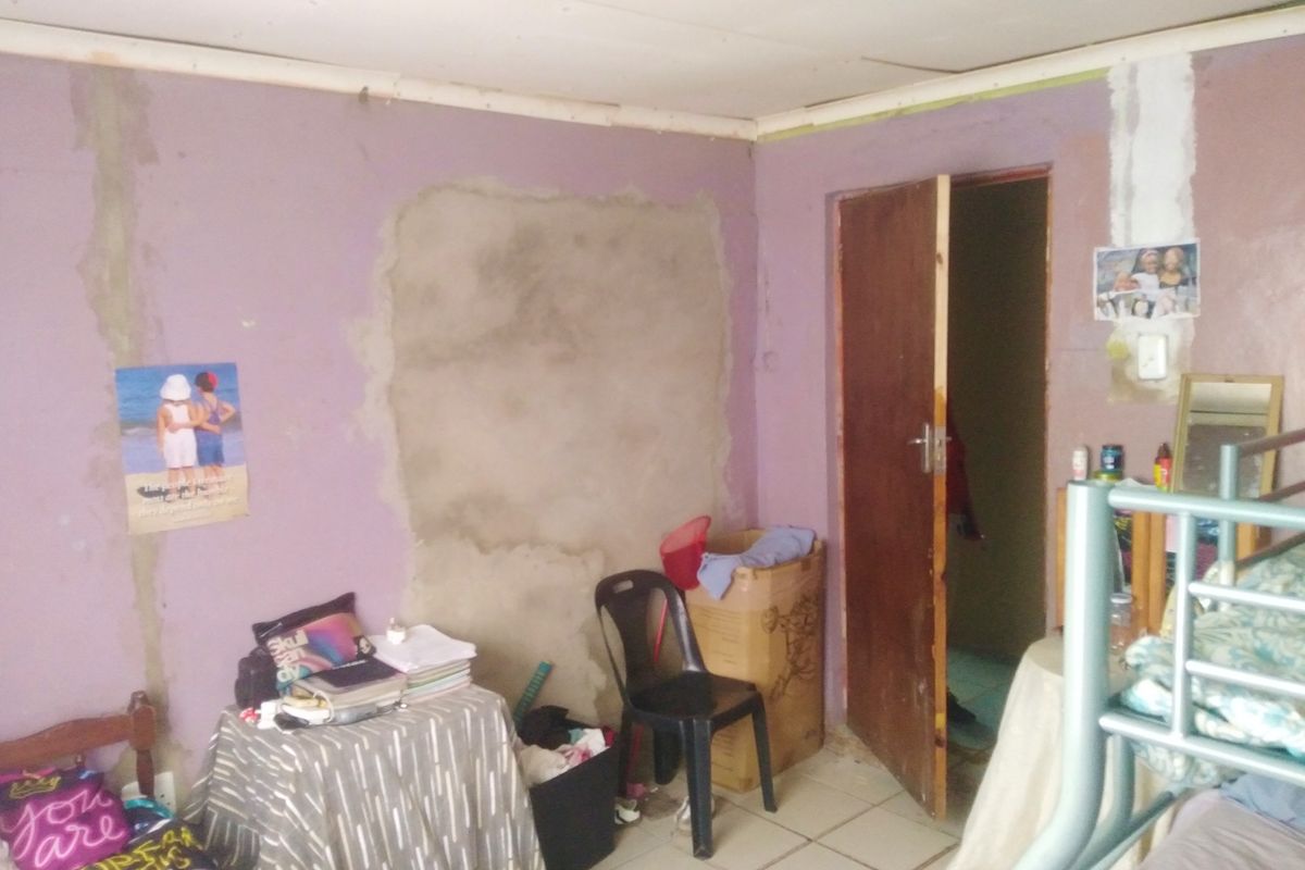A bedroom featuring tiled flooring and unfinished wall surfaces requiring cosmetic attention and repair.
