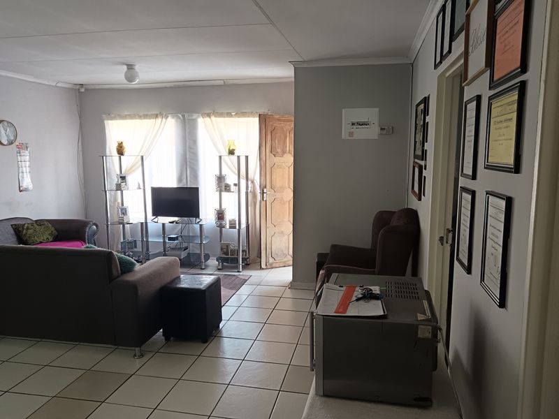 A living room featuring tiled flooring and direct access to an exterior door, providing a functional and open living space.