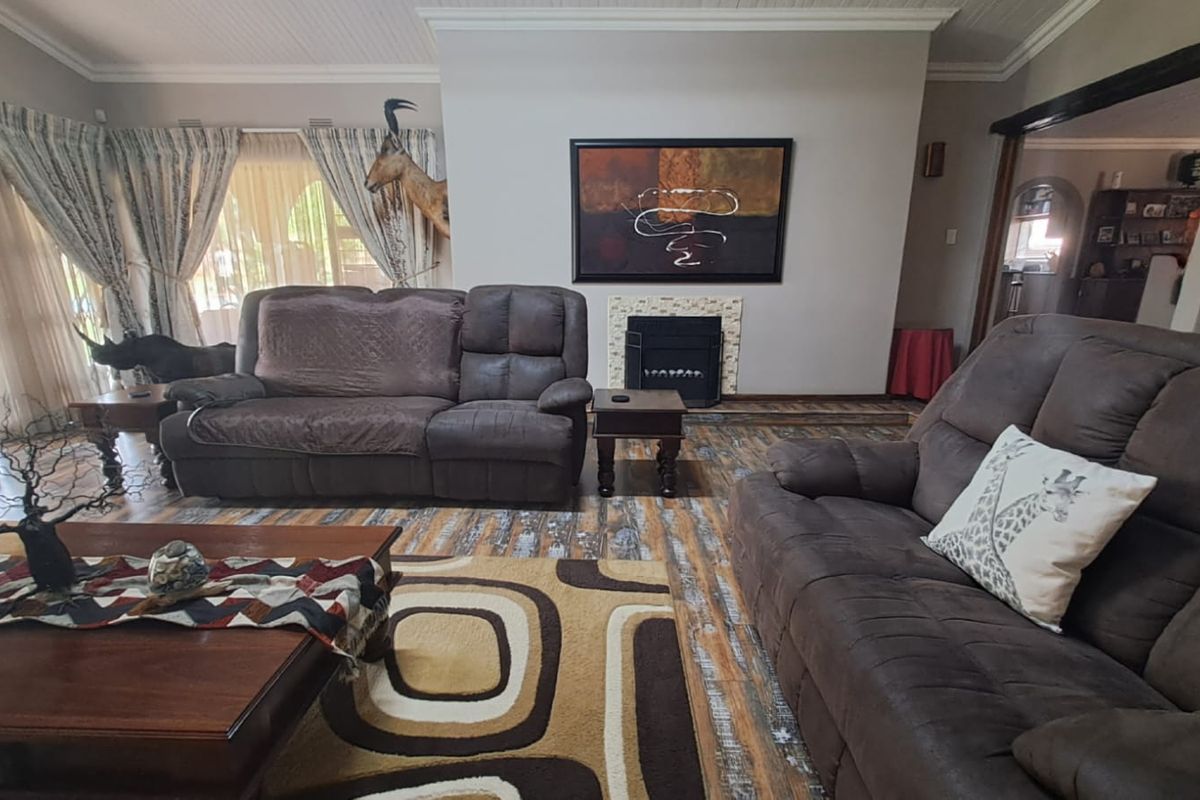 A comfortable living room featuring a built-in fireplace with a tiled surround and distinctive wood-look flooring.