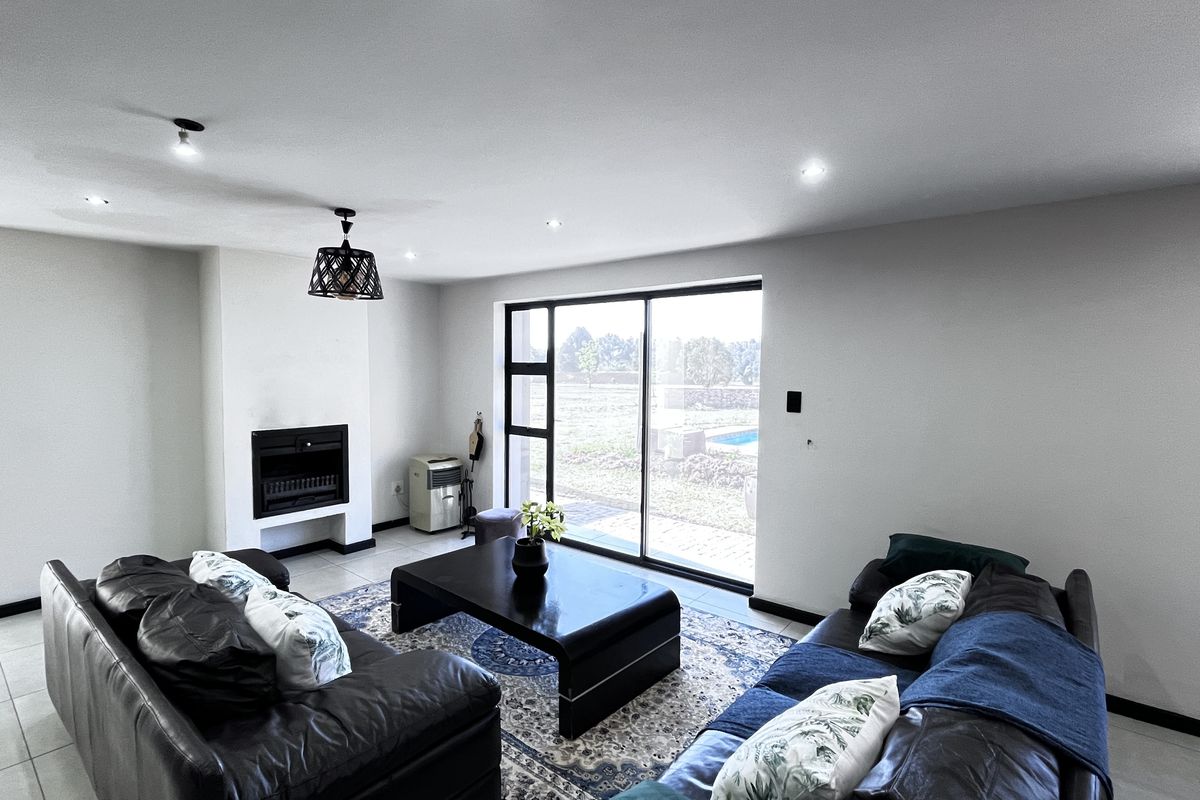 Spacious living room featuring a built-in fireplace, tiled flooring, and large sliding glass doors providing natural light and access to the outdoor area.