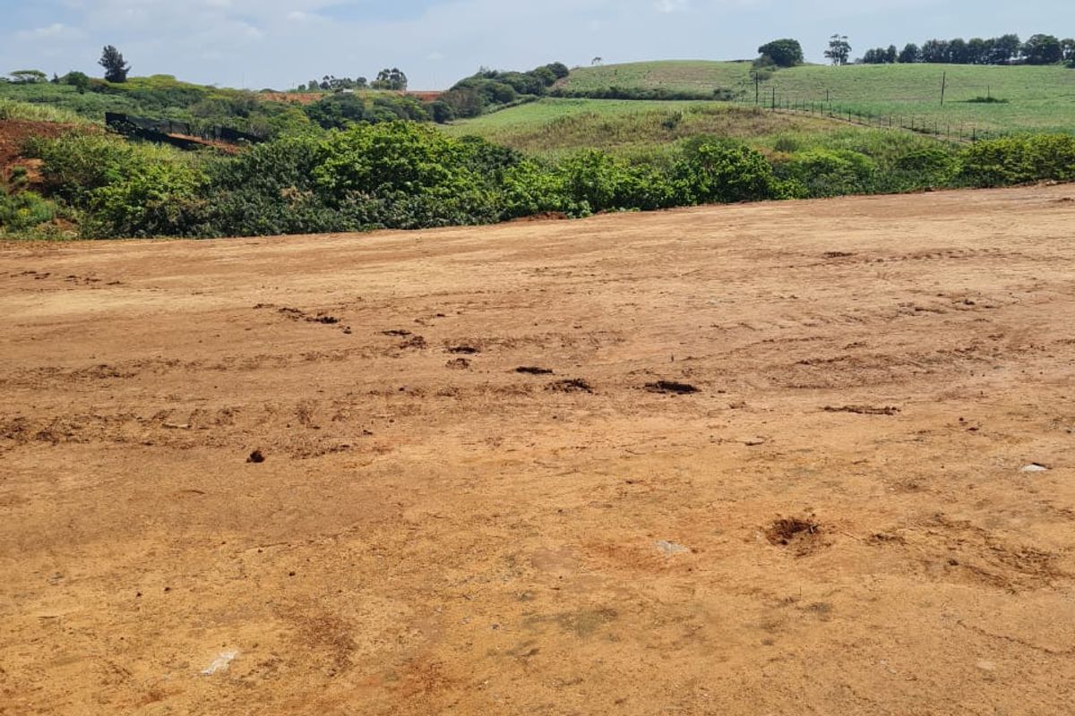 A view of a cleared residential vacant land plot with surrounding natural landscape and rolling hills.