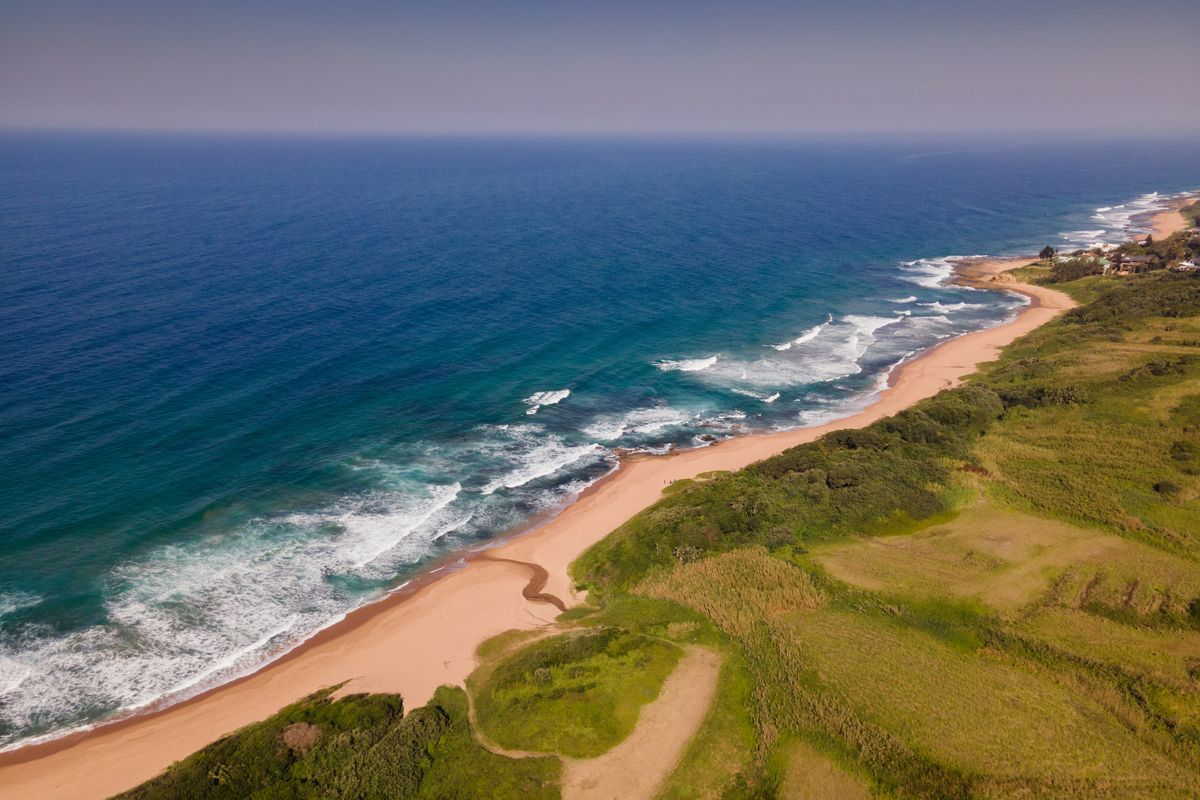 An aerial view of the coastal residential land, showcasing direct beach access and expansive ocean views.