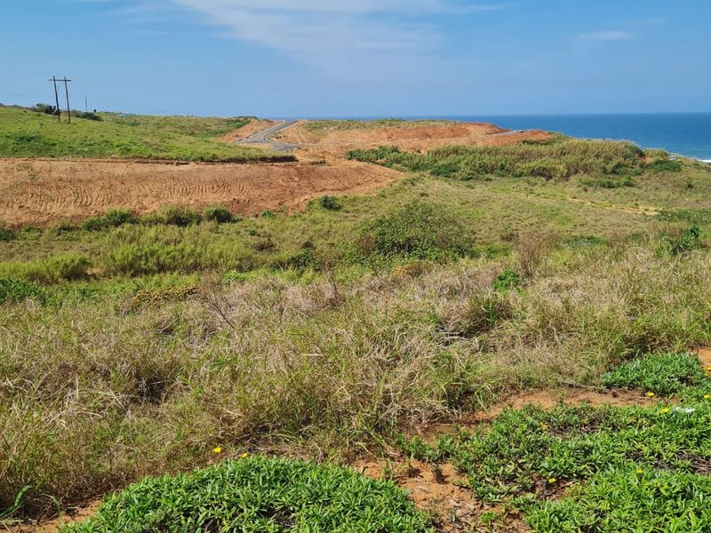 A scenic view of the coastal landscape featuring natural vegetation, open terrain, and distant ocean views.
