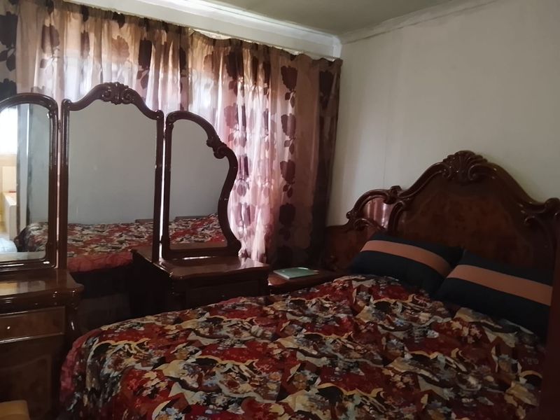 A bedroom featuring standard finishes, including a window with curtains.
