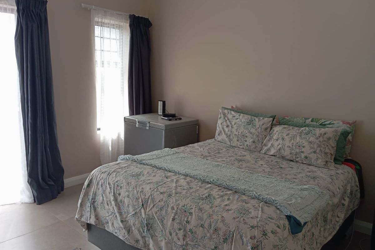 A bedroom featuring tiled flooring and a sliding door providing access to the exterior.