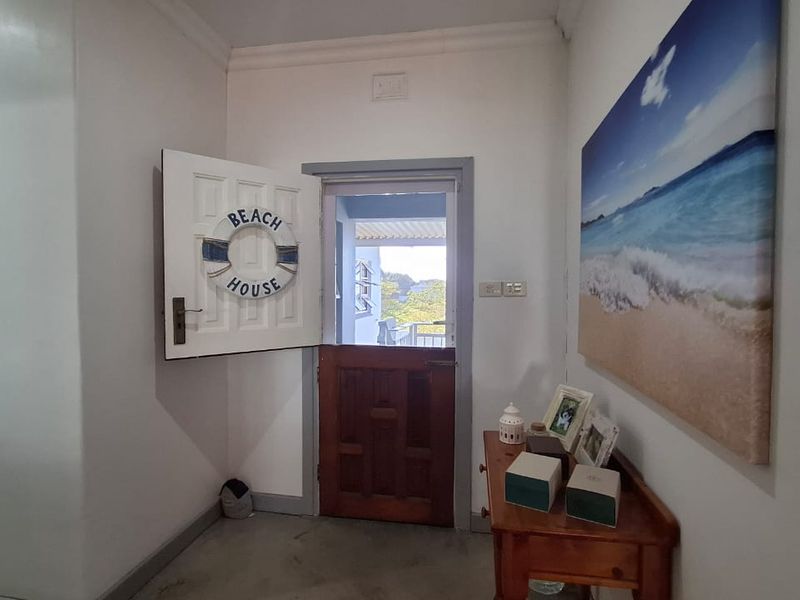 An entrance foyer featuring a traditional stable door that opens to an outdoor view, with neutral walls and classic coving detail.