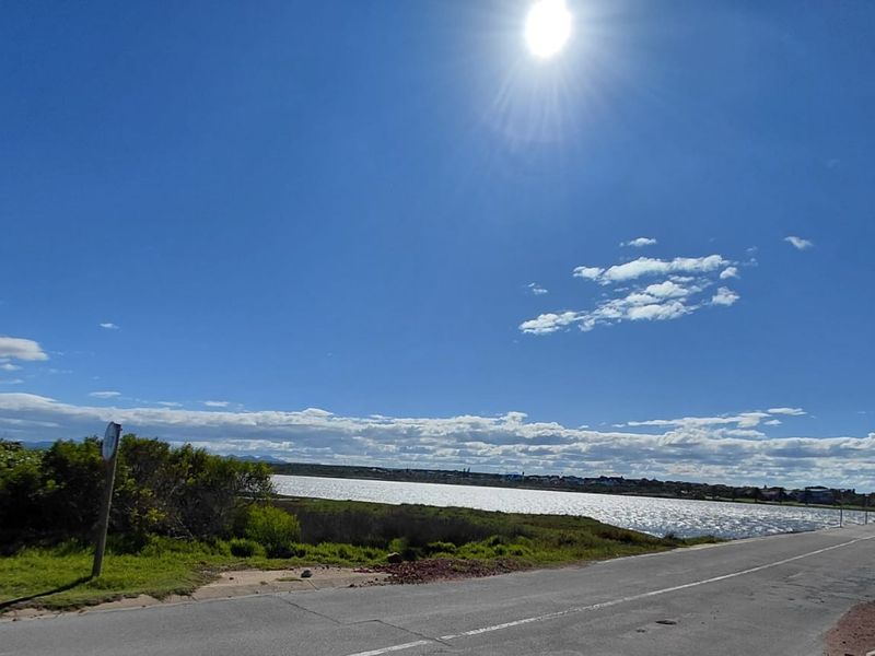 A scenic view of the coastal landscape and adjacent water body from the roadside.