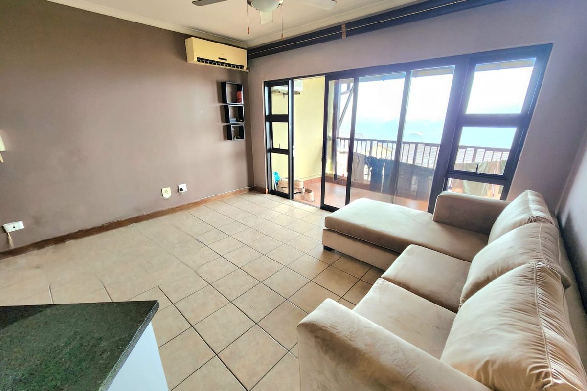 Living room featuring tiled flooring, a ceiling fan, split-system air conditioning, and sliding glass doors leading to an outdoor balcony area.