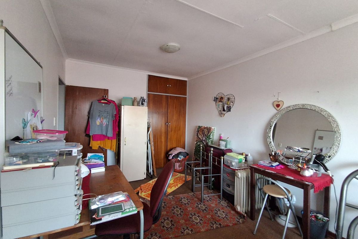 A bedroom featuring built-in wooden cupboards and carpeted flooring, offering functional storage space.