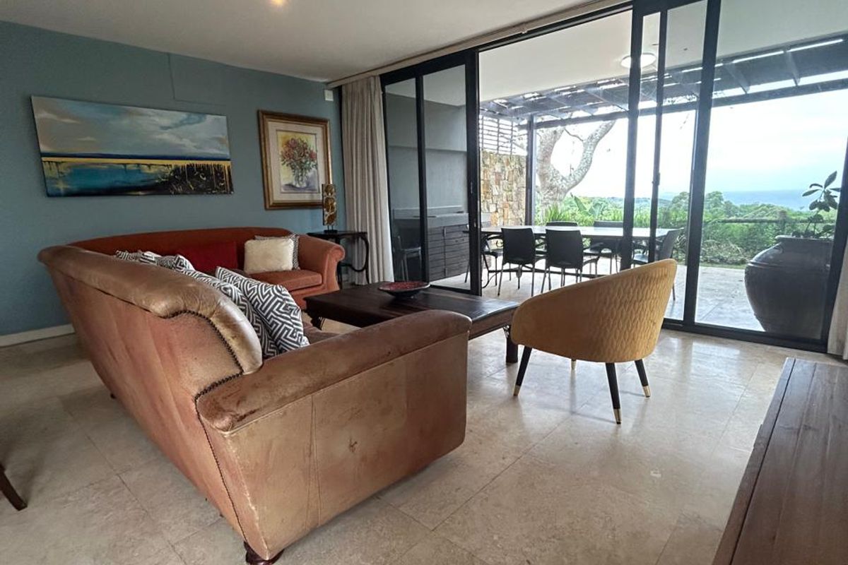 Spacious living area featuring large sliding glass doors that open onto a covered patio with scenic views.