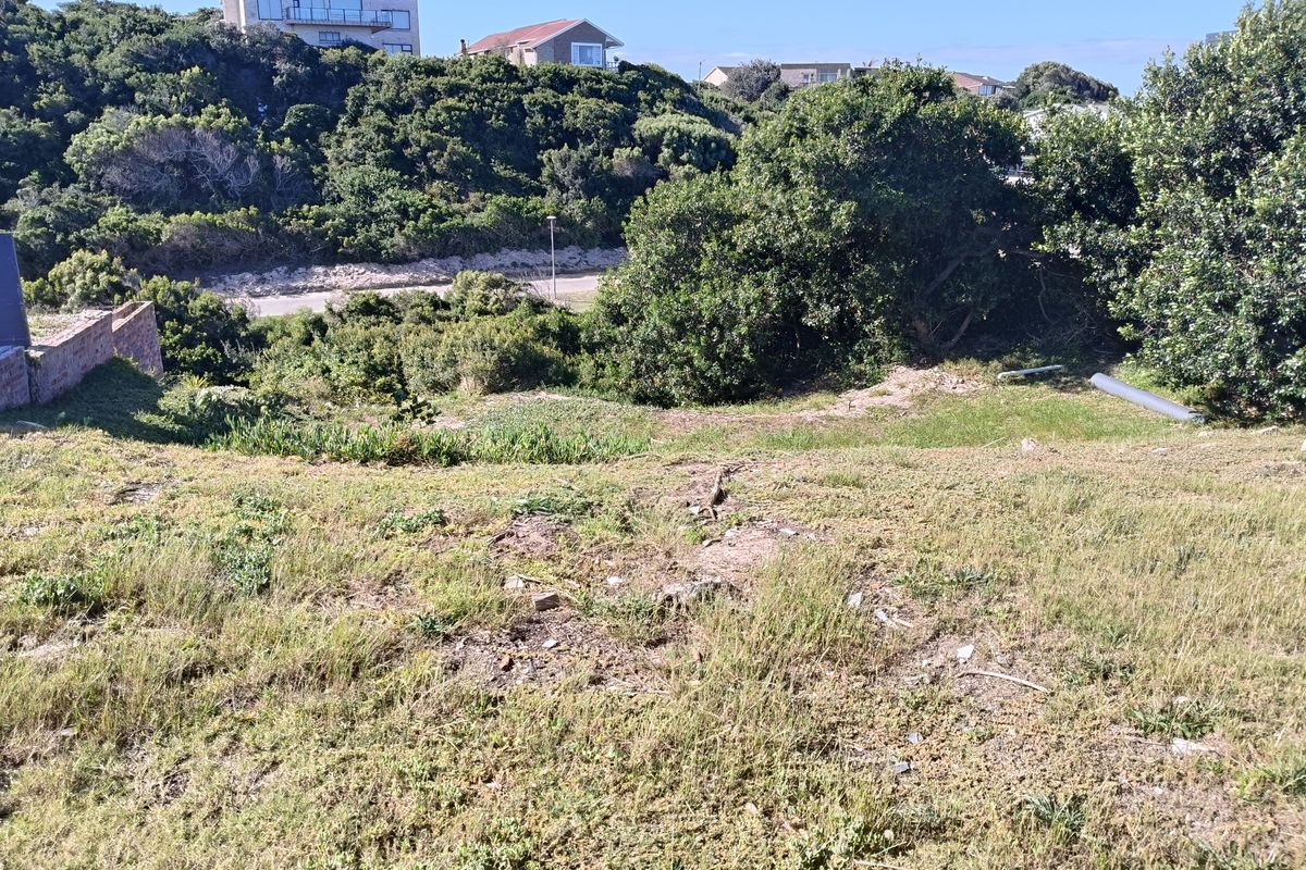 A view of the sloped, undeveloped residential land featuring natural vegetation and surrounding neighborhood landscape.