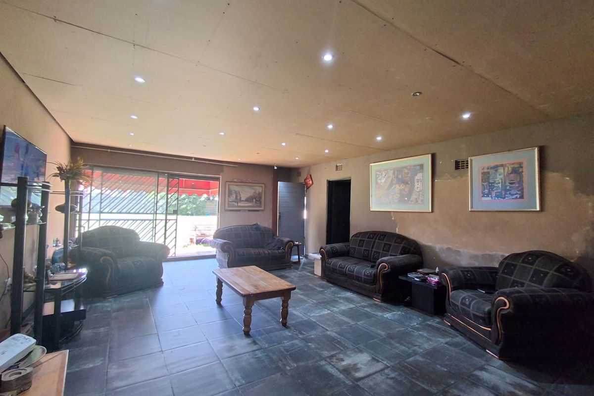 Spacious living room featuring tiled flooring, recessed ceiling lighting, and sliding glass doors providing access to the outdoor area.