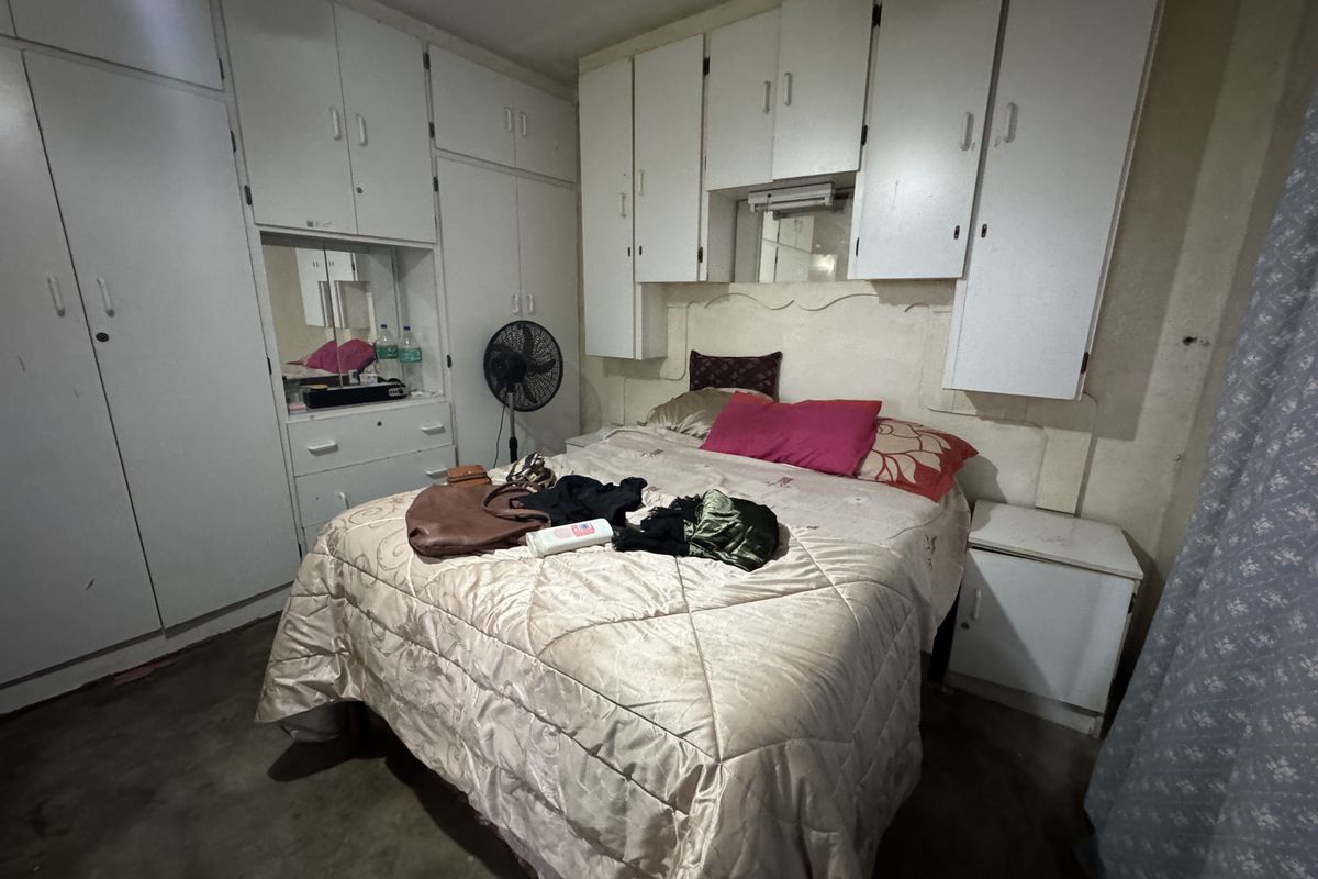 Bedroom featuring extensive built-in cabinetry and overhead storage units, providing ample storage space within the room.