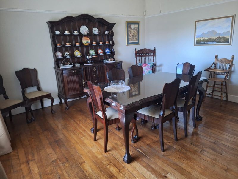 A traditional dining room featuring original hardwood flooring, picture rails, and coved ceilings, offering a classic foundation for modern updates.