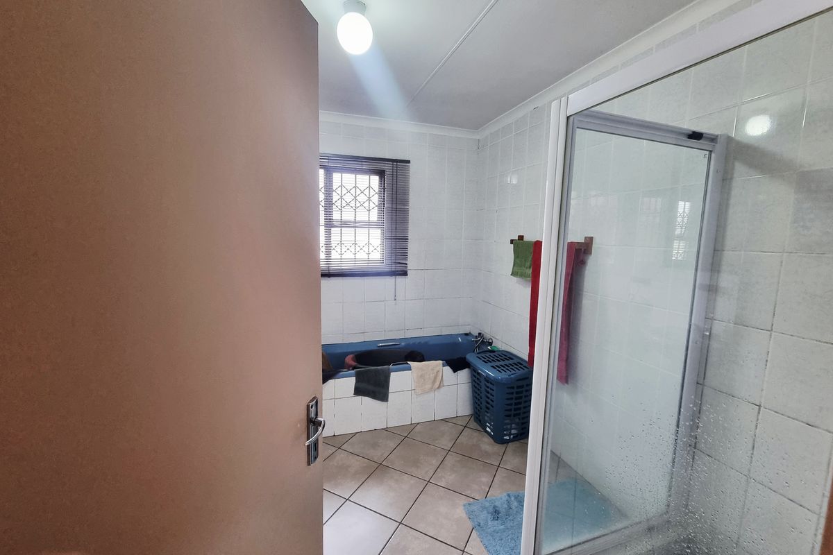 A functional bathroom featuring a separate shower enclosure, a built-in bathtub, and tiled walls and flooring.