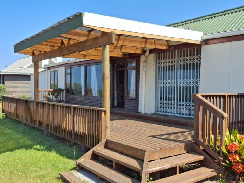 A spacious timber deck featuring a pergola and security gate, providing an outdoor living area with direct access to the garden.