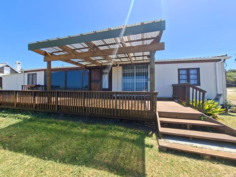 A spacious timber deck featuring a covered pergola, built-in balustrades, and stairs leading to the garden area.