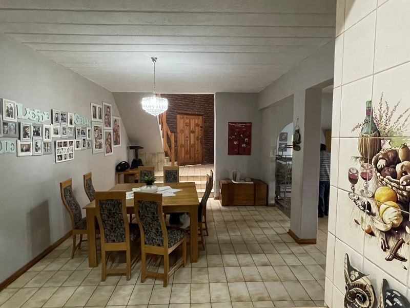 A dining area featuring tiled flooring, a timber staircase, and a decorative ceiling, providing a functional space for family meals.