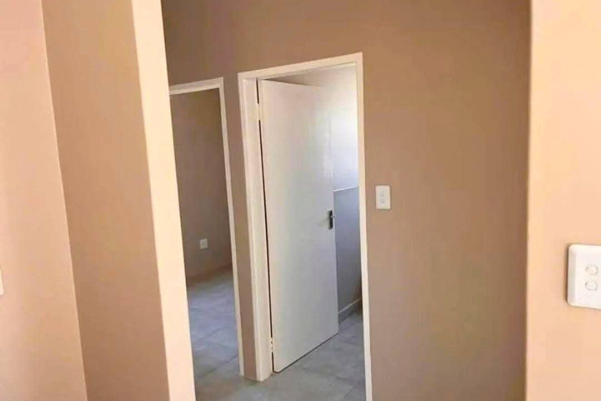 A view through a hallway showing internal doors and tiled flooring, providing access to adjacent rooms within the townhouse.