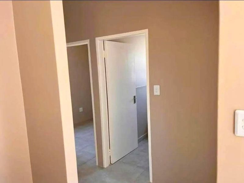 A view through a hallway showing internal doors and tiled flooring, providing access to adjacent rooms within the townhouse.