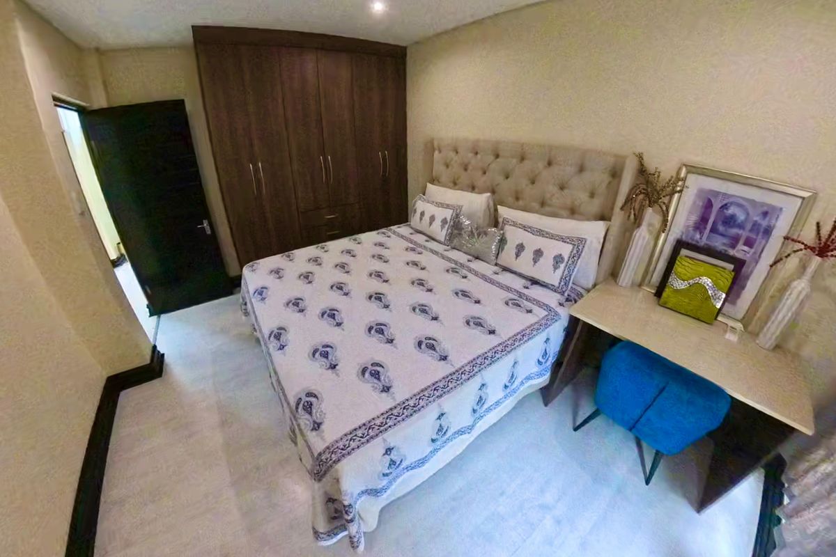 A well-maintained bedroom featuring built-in wooden cabinetry and neutral finishes, providing a clean and functional living space.