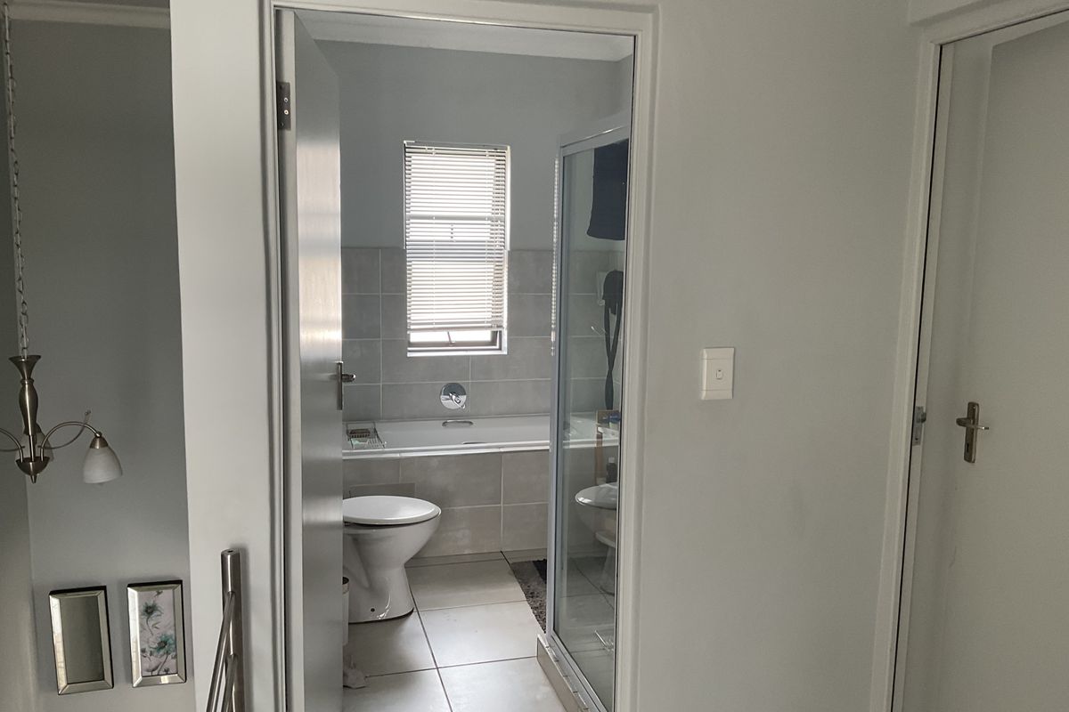 A view into a functional bathroom featuring a built-in bathtub, a separate glass-enclosed shower, and tiled flooring.