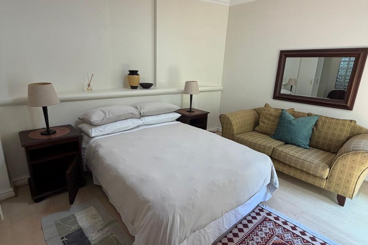 A bedroom featuring a built-in wall ledge and decorative coving, providing a functional space with neutral wall finishes.