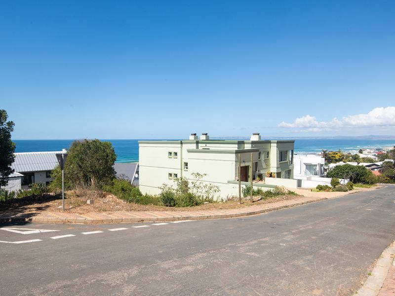 Street view of a residential property situated in a coastal neighborhood with clear views of the ocean.