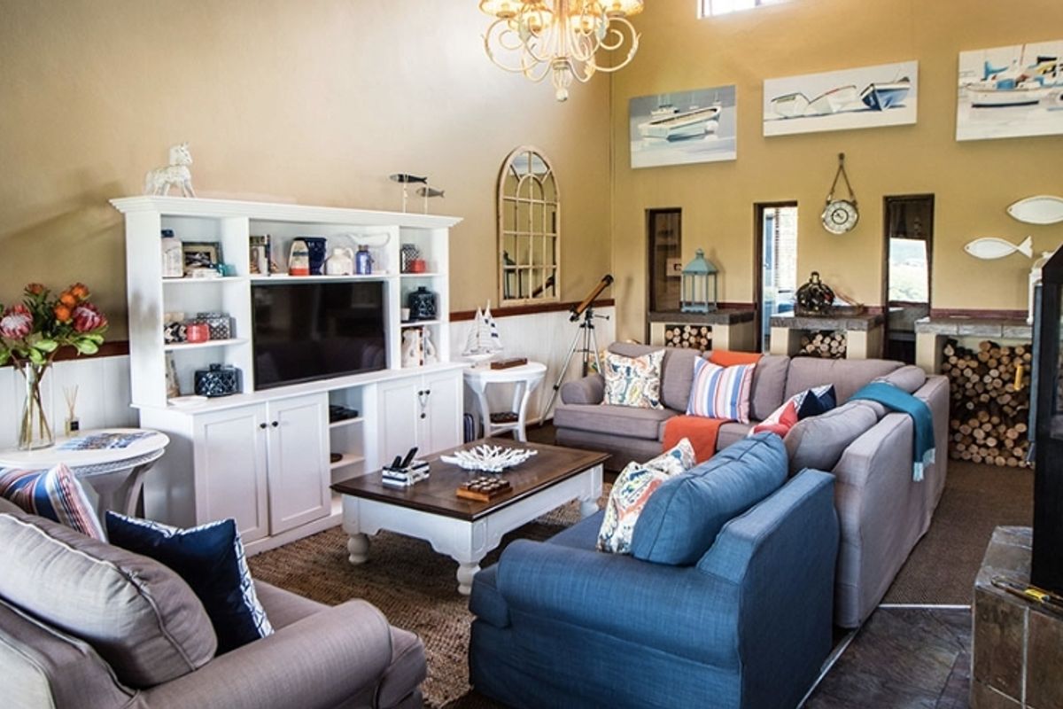 Spacious living room featuring high ceilings, a built-in media cabinet, and a prominent fireplace with integrated wood storage.