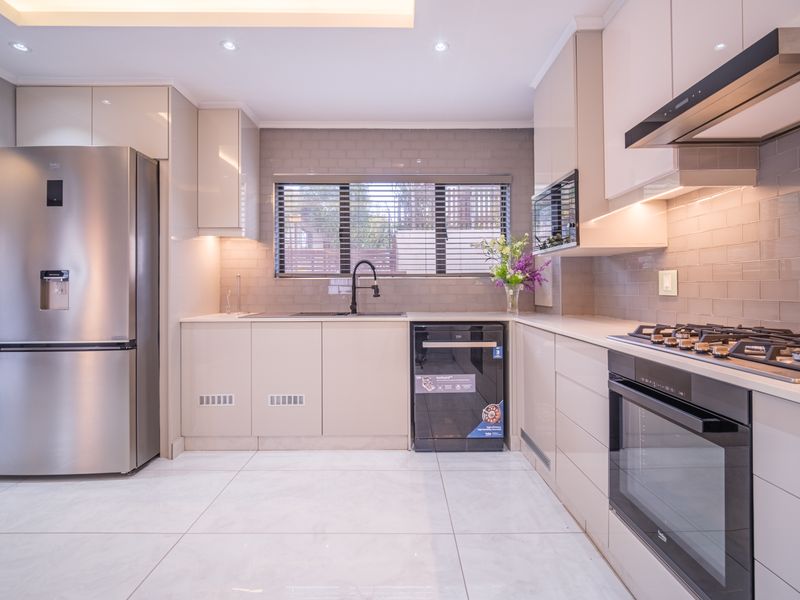 Modern kitchen featuring high-gloss cabinetry, stone countertops, subway tile backsplash, integrated oven, gas hob, extractor fan, and recessed ceiling lighting.