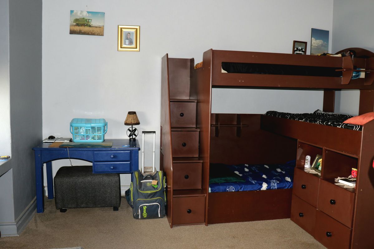 A bedroom featuring carpeted flooring and neutral wall finishes, providing a functional space for rest and study.