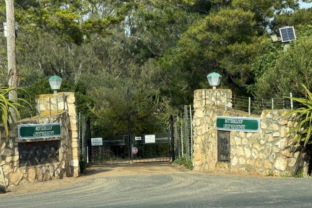 Entrance gate to Botterkloof Lifestyle Estate featuring stone pillars, wrought iron gates, and estate signage.