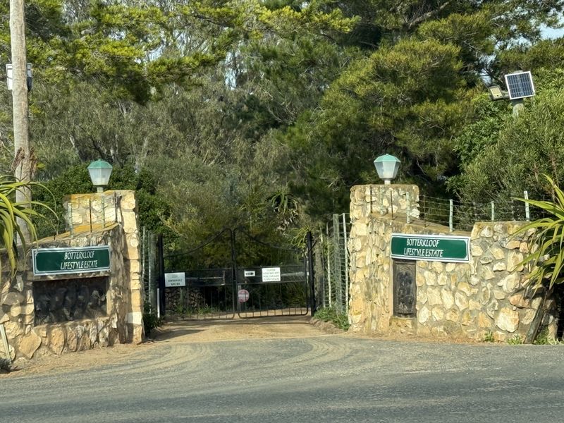 Entrance gate to Botterkloof Lifestyle Estate featuring stone pillars, wrought iron gates, and estate signage.