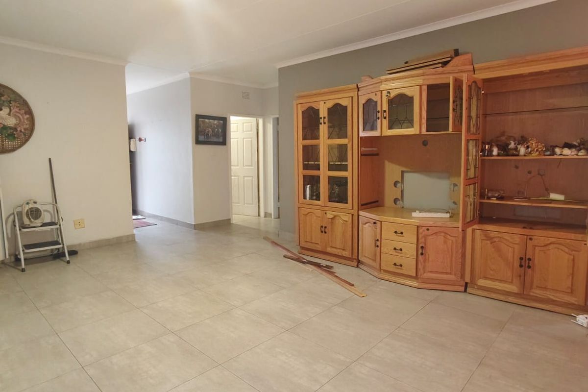 Spacious living area featuring neutral floor tiles and a neutral color palette, providing a versatile foundation for your interior design preferences.