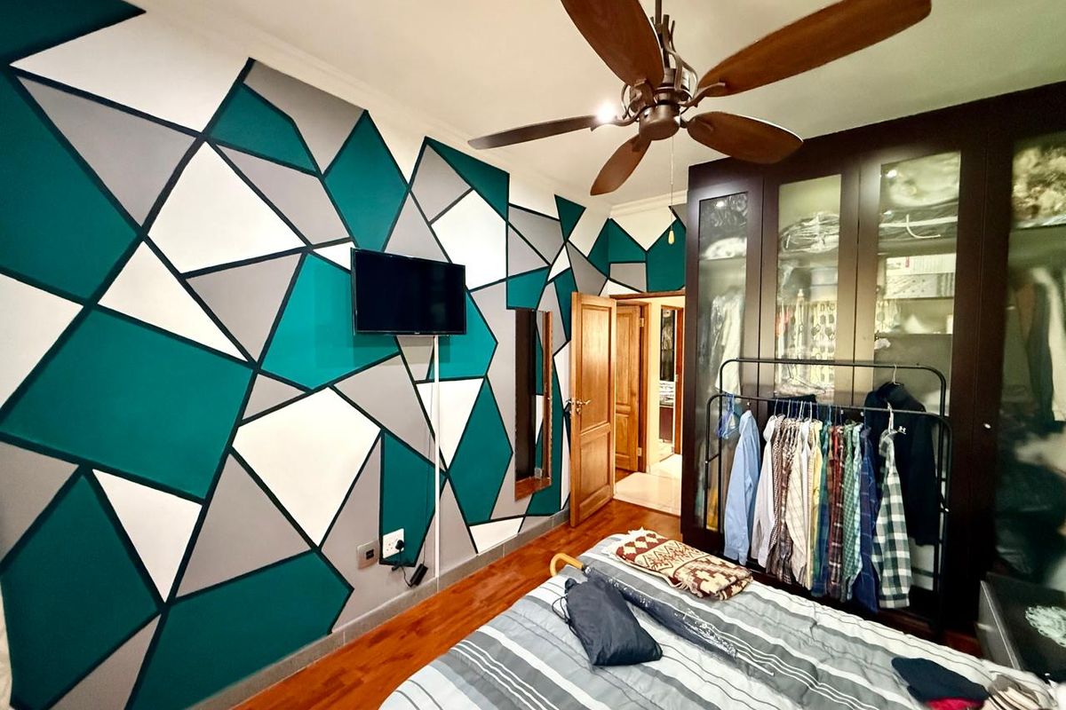 Bedroom featuring hardwood flooring, a ceiling fan, and built-in dark wood cabinetry with glass-fronted doors.