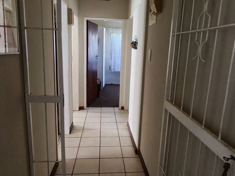 A functional interior hallway featuring tiled flooring and access to multiple rooms, providing a central circulation space within the home.