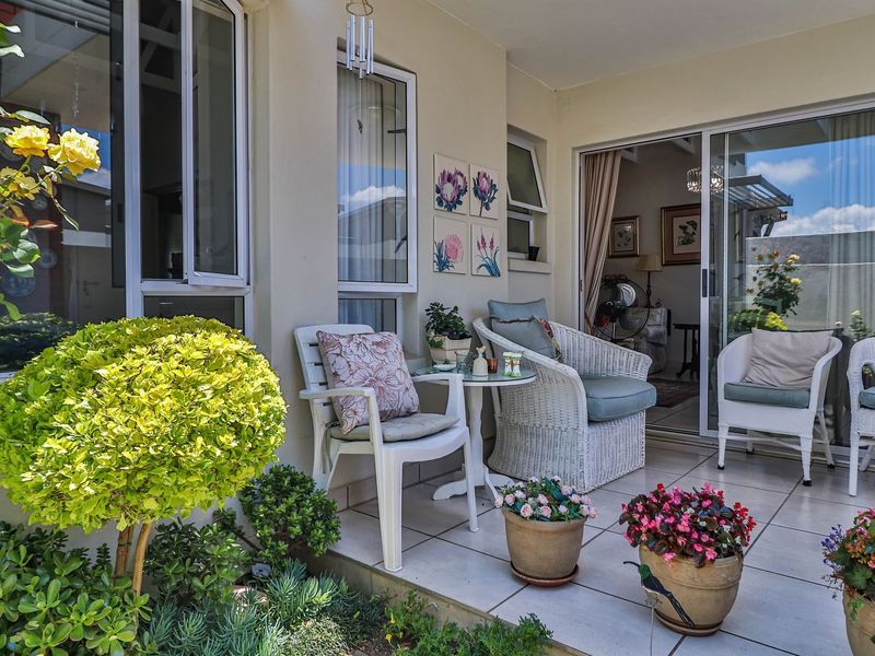 A well-maintained covered patio featuring tiled flooring and large sliding glass doors that provide seamless access to the interior living space.