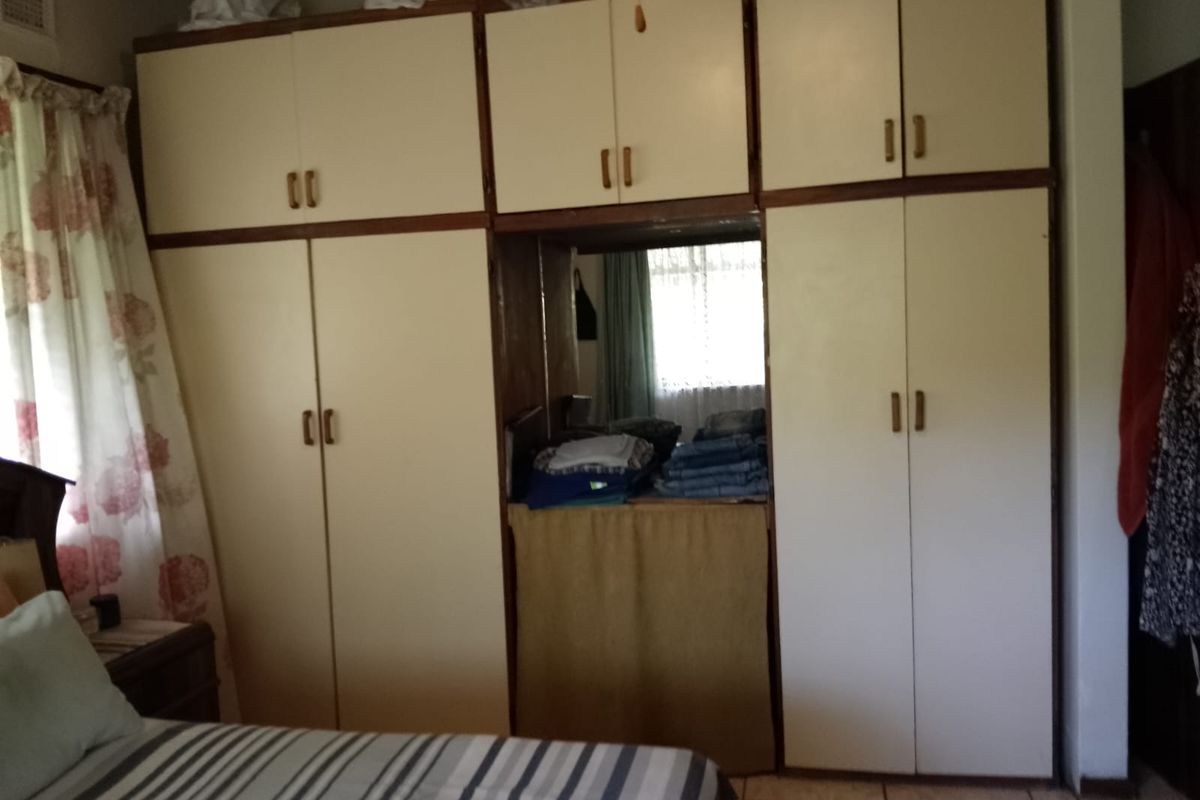 Bedroom featuring extensive built-in floor-to-ceiling cabinetry with integrated storage and central vanity or display niche.