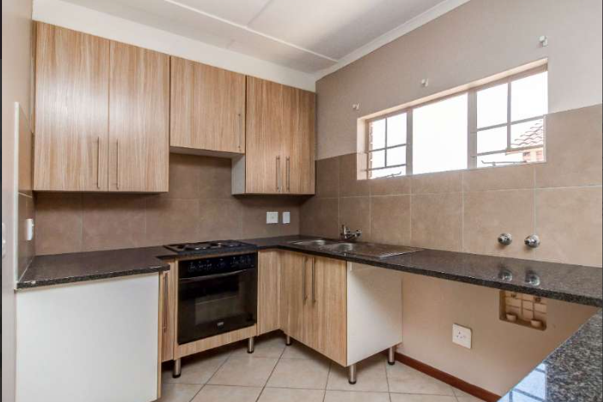 A functional kitchen featuring laminate cabinetry, granite countertops, a built-in oven, and a tiled backsplash, offering a practical layout for daily use.