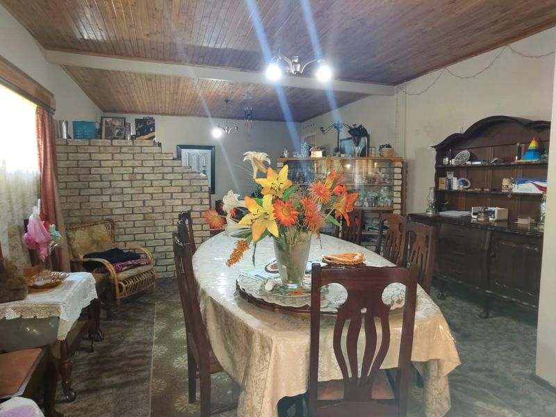 Dining room featuring a timber-clad ceiling and a decorative brick partition wall, creating a traditional and distinct living space.