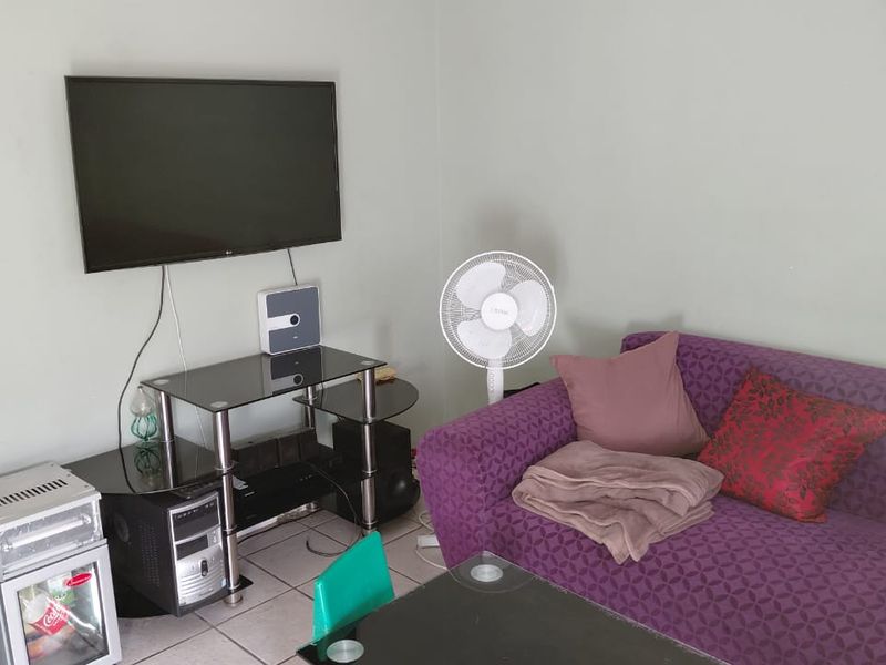 A living room area featuring tiled flooring and neutral wall finishes, providing a functional space for relaxation.