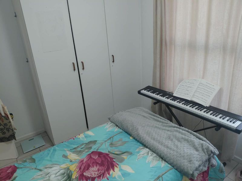 A bedroom featuring built-in cupboards and tiled flooring, providing functional storage space.