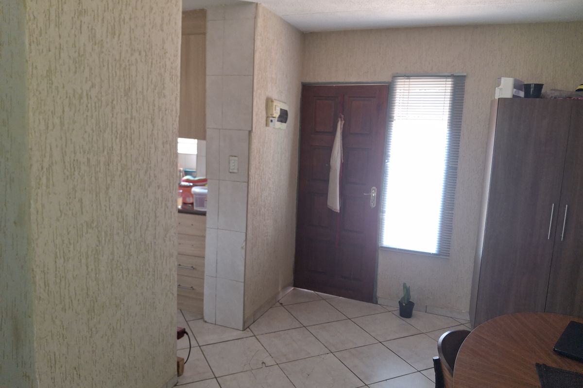 Entrance area featuring tiled flooring and textured wall finishes, providing direct access to the living space and adjacent kitchen area.