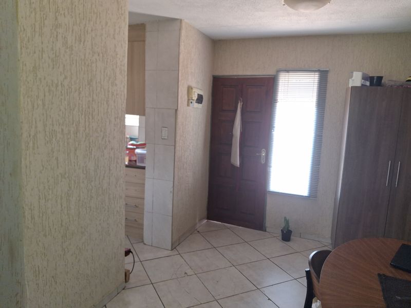 Entrance area featuring tiled flooring and textured wall finishes, providing direct access to the living space and adjacent kitchen area.