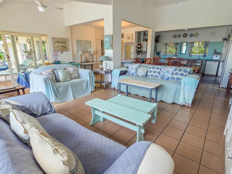 Spacious open-plan living and dining area featuring tiled flooring, ceiling fan, and direct access to an outdoor patio through sliding glass doors.