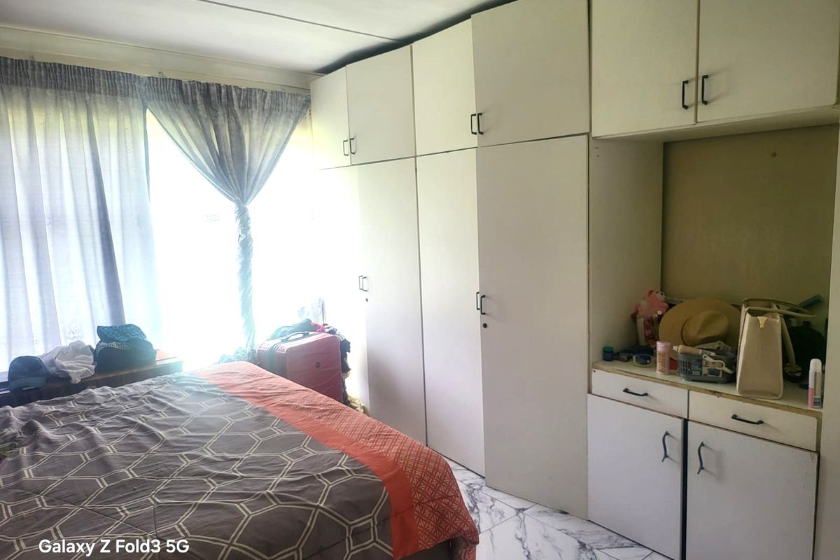Bedroom featuring extensive built-in white cabinetry with integrated storage and marble-look tiled flooring.