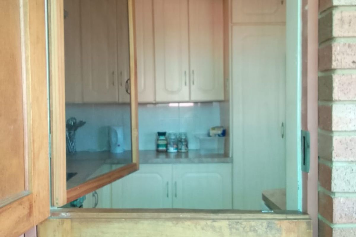 View into a kitchen featuring traditional built-in cabinetry and a classic stable door entrance.