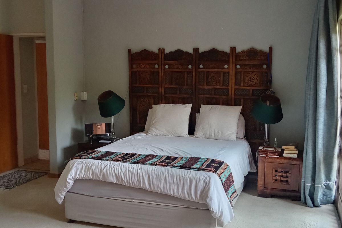 Spacious bedroom featuring neutral wall tones, carpeted flooring, and direct access to an outdoor area through sliding doors.