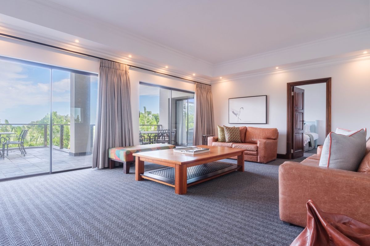 Spacious living room featuring large sliding glass doors that open onto a private balcony, providing ample natural light and seamless indoor-outdoor flow.